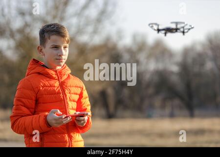 Un adolescent volant un petit drone dans le parc Banque D'Images