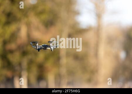 Petit drone avec petit appareil photo volant dans le parc Banque D'Images