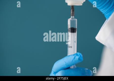 Une infirmière prélève une solution antibiotique ou des vitamines dans un flacon transparent avec une seringue d'injection. Banque D'Images