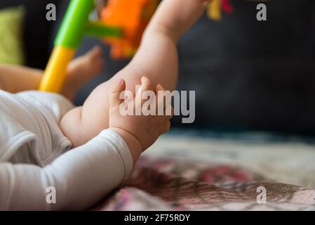 Mains et pieds d'un bébé allongé sur une couverture. La main tendue de bébé. Soins de bébé. Banque D'Images