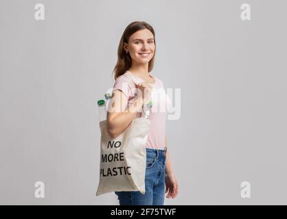 Jeune femme souriante transportant un sac fourre-tout Eco sans plus Inscription en plastique Banque D'Images