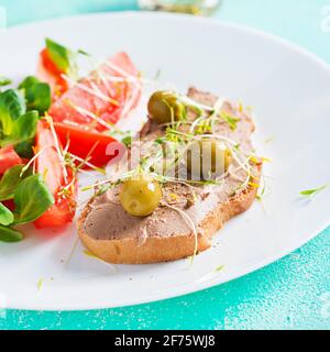 Pâté de foie de poulet maison frais sur du pain et de la salade de tomates. Petit déjeuner. Banque D'Images