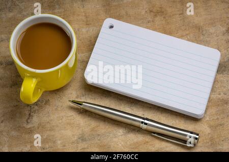 Une pile de cartes vierges avec une tasse de café et un stylo contre le papier d'écorce texturée Banque D'Images