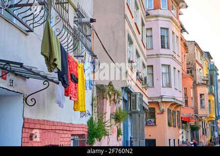 La vie habituelle. Les vêtements multicolores sèchent sur la corde. Un vieux quartier pittoresque d'Istanbul. Maisons basses colorées et rues étroites et confortables. Banque D'Images