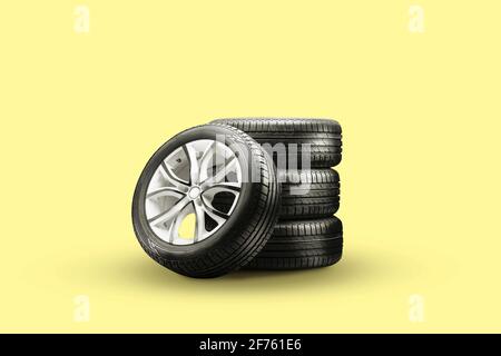 pneus et roues d'été – empiler sur fond jaune, nouvelles roues. Banque D'Images