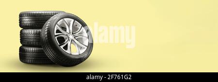 pneus d'été et roues-empiler sur fond jaune, nouvelles roues de longue durée sans espace de copie. Banque D'Images