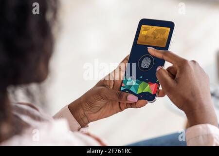 Femme noire payant en ligne avec Touch ID, en utilisant le téléphone portable Banque D'Images