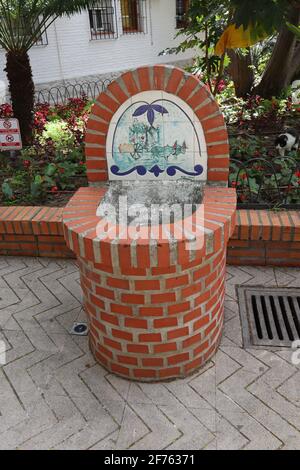 Une fontaine en briques et carreaux de céramique dans un parc public d'Estepona, en Espagne Banque D'Images