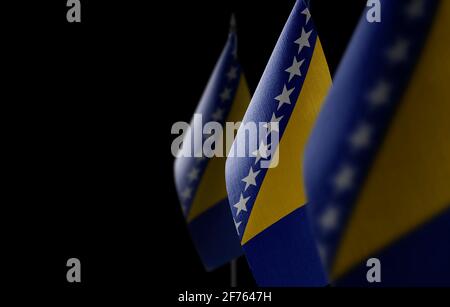 Petits drapeaux nationaux de la Bosnie-Herzégovine sur un arrière-plan noir Banque D'Images