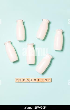 Petits flacons avec probiotiques et prébiotiques boisson laitière sur fond bleu. Production avec des additifs biologiquement actifs. Fermentation et régime guérir Banque D'Images