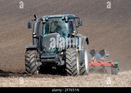 Un agriculteur labourage en chaume après avoir récolté la récolte à l'aide d'un tracteur Valtra et d'une charrue à 5 sillons. North Yorkshire, Royaume-Uni. Banque D'Images