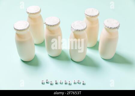 Petits flacons avec probiotiques et prébiotiques boisson laitière sur fond bleu. Production avec des additifs biologiquement actifs. Fermentation et régime guérir Banque D'Images