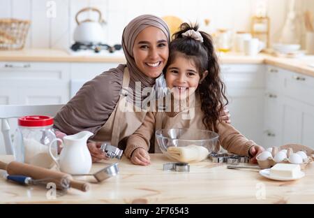 Bonne mère de famille islamique et petite fille se cuisant ensemble Dans la cuisine Banque D'Images