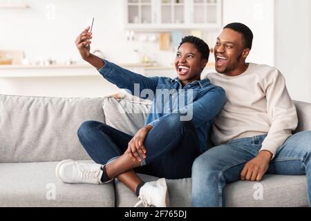 Portrait d'un couple noir prenant le selfie ensemble à la maison Banque D'Images