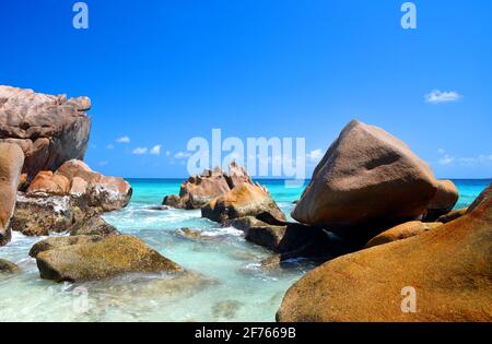 Grands rochers de granit dans la plage d'Anse Patates, l'île de la Digue, l'océan Indien, Seychelles. Magnifique paysage tropical avec ciel ensoleillé. Banque D'Images