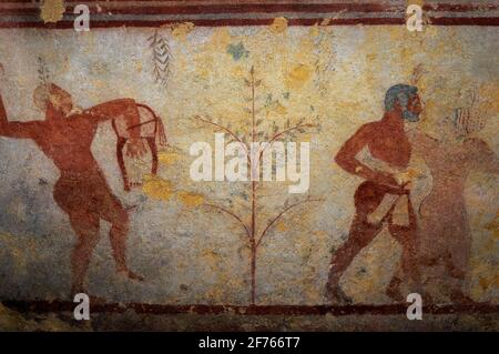 Un joueur de lyre ou de harpe étrusque (à gauche) et un barbu avec une danseuse. Détail de peinture murale dans le tombeau étrusque des Bacchants, vieux de 2 500 ans, ou tomba dei Baccanti, dans la nécropole Monterozzi de l'ancienne ville de Tarchuna ou Tarchna, aujourd'hui Tarquinia, Latium, Italie. La chambre funéraire date de 510 à 500 av. J.-C. Le musicien représenté ici accompagne un spectacle bacchanalien ivre, montré ailleurs dans la fresque. Banque D'Images