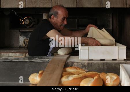 Baker prépare du pain à la boulangerie. Banque D'Images