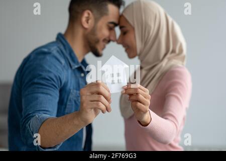 Jeune couple musulman tenant une maison de papier, foyer sélectif Banque D'Images