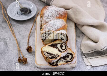 Gâteau avec garniture de pavot et têtes de graines sur fond de béton gris. Style rustique. Banque D'Images