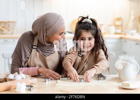 Adorable petite fille arabe s'amuser tout en cuisant avec mère Dans la cuisine Banque D'Images