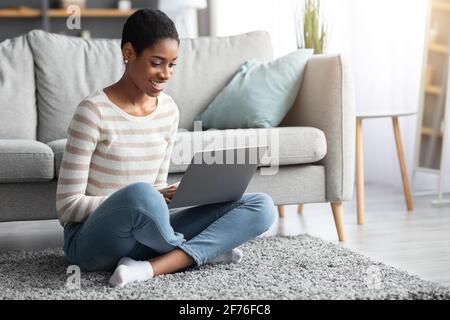 Travail à distance. Femme freelante noire souriante travaillant avec un ordinateur portable à la maison Banque D'Images