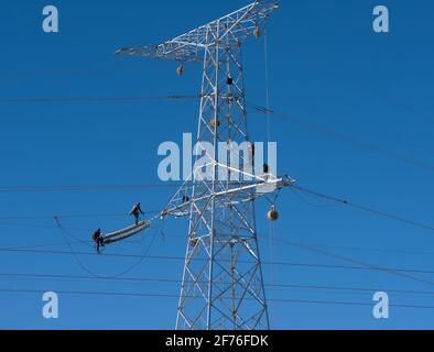 Travailleurs de maintenance travaillant sur des tours en acier de lignes électriques haute tension Banque D'Images