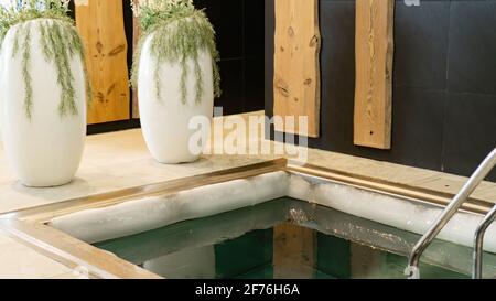 Bord de glace sur le bord du bain plongeant avec de l'eau très froide pour durcir le corps dans le complexe de sauna. Plongez dans l'eau froide après un sauna chaud. Extrême Banque D'Images