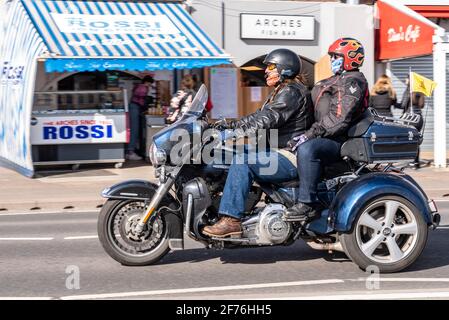 Southend on Sea, Essex, Royaume-Uni. 5 avril 2021. Le lundi de Pâques s'est dégagé dans un après-midi ensoleillé mais frais, avec un vent frais fort. Harley Davidson trois motos à roues passant devant les entreprises de bord de mer Banque D'Images