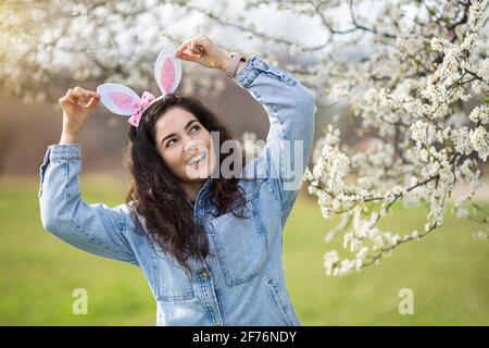 Bonne jeune femme souriante portant des oreilles de lapin Banque D'Images