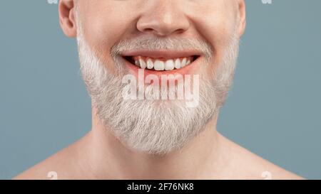 Portrait court d'albinos avec grand sourire et dents saines, sur fond turquoise studio, gros plan Banque D'Images