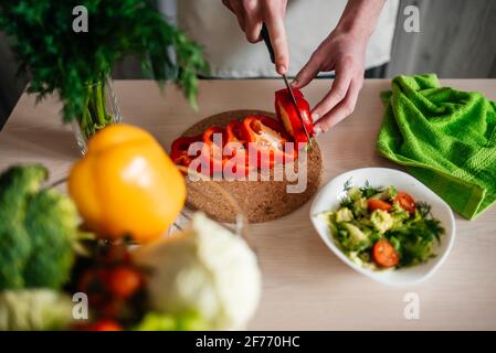 les hommes hacher la salade et l'oignon, cuisiner des aliments sains dans la cuisine. Banque D'Images