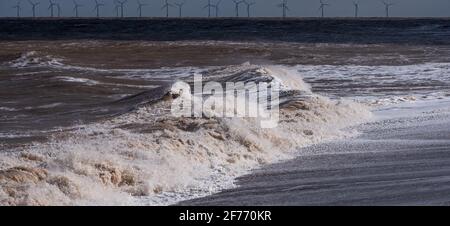 Puissantes vagues de la mer du Nord frappant les plages de La côte du Lincolnshire montrant la puissance brute de la mer et la vie recherchée par les habitants de la ville Banque D'Images