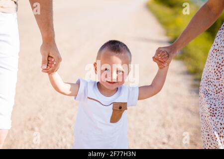 Bonne enfance d'un enfant avec maman et papa. L'enfant tient la main des parents. Banque D'Images