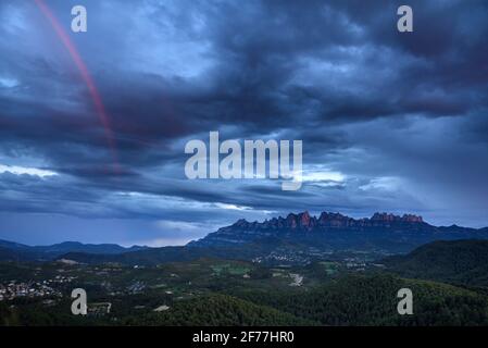 Montagne de Montserrat dans un ciel nuageux coucher de soleil avec un arc-en-ciel (province de Barcelone, Catalogne, Espagne) ESP: Macizo de Montserrat al atardecer (Cataluña) Banque D'Images