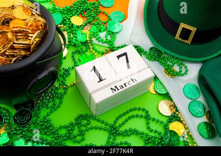 La chance du thème du concept de la fête irlandaise et de la Saint Patrick avec un calendrier, un chapeau de lepretchun, un collier de perles et un pot de pièces d'or sur l'Irelan Banque D'Images