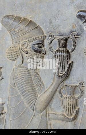 Iran, Persepolis, classé au patrimoine mondial de l'UNESCO, escalier oriental d'Apadana, Bas relief représentant un affluent arménien apportant du vin au roi Banque D'Images