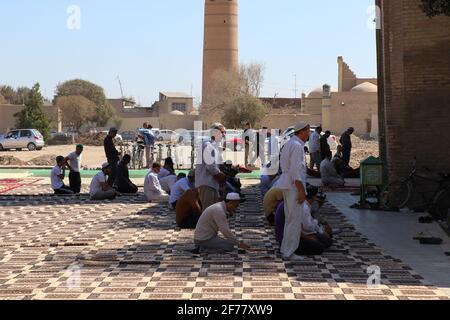 Musulmans, priant devant une mosquée, Xiva, Ouzbékistan Banque D'Images