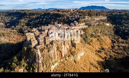Carte postale d'Italie. Vue aérienne du village médiéval de Calcata avec sa falaise volcanique et la vallée de la rivière Treja avec le Mont Soratte Banque D'Images