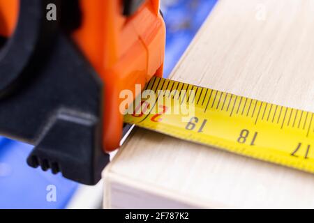 Mesure d'une planche en bois à l'aide d'un ruban de construction Banque D'Images