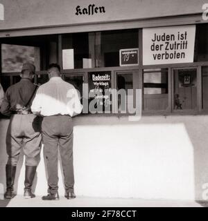 ANNÉES 1930 ANNÉES 1940 DEUX HOMMES UN DANS LE JACK DE MAILLOT DE CHAPEAU NAZI L'AFFICHE BOOTS AT COFFEE SHOP DANS LA FENÊTRE INDIQUE L'ENTRÉE DE LES JUIFS SONT INTERDITS ALLEMAGNE - S5962 HAR001 HARS ALLEMAGNE PLEINE LONGUEUR PERSONNES HOMMES RISQUE B&W TRISTESSE EST DÉSASTRE RELIGIEUX EXTÉRIEUR INTERDIT SONT À L'ADMISSION POLITIQUE CONCEPTUELLE DE PERSÉCUTION FASCISTE NAZIE ADMITTANCE LE FASCISME DIT L'ANTISÉMITISME NOIR ET BLANC DE RACE BLANCHE HAR001 ANCIENNE RESTRICTION Banque D'Images