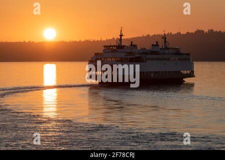 Vashon Island, WA, États-Unis - 18 juillet 2018 ; MV Sealth laisse Vashon Island rétroéclairé par un soleil orange brillant sur un ferry régulier Banque D'Images