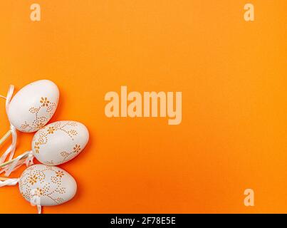 Œufs de Pâques blancs sur fond orange. Concept vacances de printemps Banque D'Images