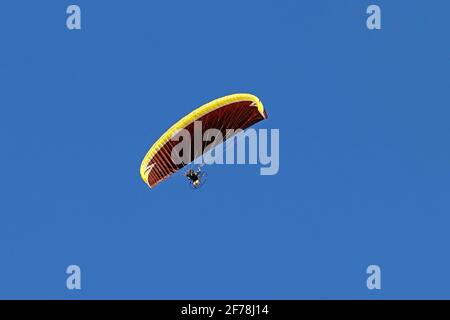 Paramoteur en vol contre le ciel bleu. Un parapente avec moteur Banque D'Images