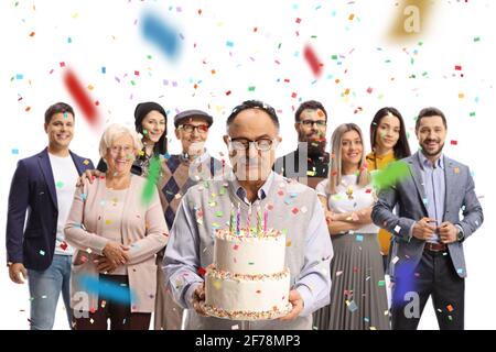 Homme âgé célébrant avec un gâteau d'anniversaire avec sa famille rassemblé autour isolé sur fond blanc Banque D'Images