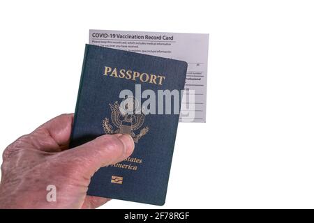 Homme senior tenant le passeport américain et le certificat de vaccination ou carte d'enregistrement pour le coronavirus Banque D'Images