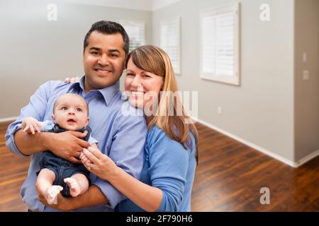 Jeune couple avec bébé dans la chambre vide de la nouvelle maison. Banque D'Images