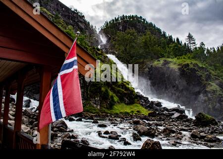 Latefossen Latefoss - l'une des plus grandes cascades de Norvège, avec un drapeau national sur un bâtiment à proximité Banque D'Images