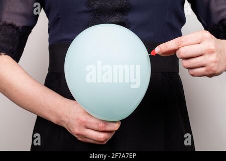 Estomac gonflé. Douleur et problèmes de santé. Femme avec un ballon bleu et une aiguille. Banque D'Images