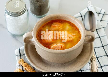 soupe maison avec saumon et bâtonnets de pain sur fond de marbre Banque D'Images