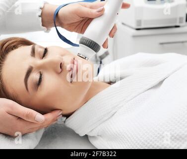 Femme adulte pendant le levage rf visage resserrage avec son esthéticienne dans un salon de beauté, gros plan Banque D'Images